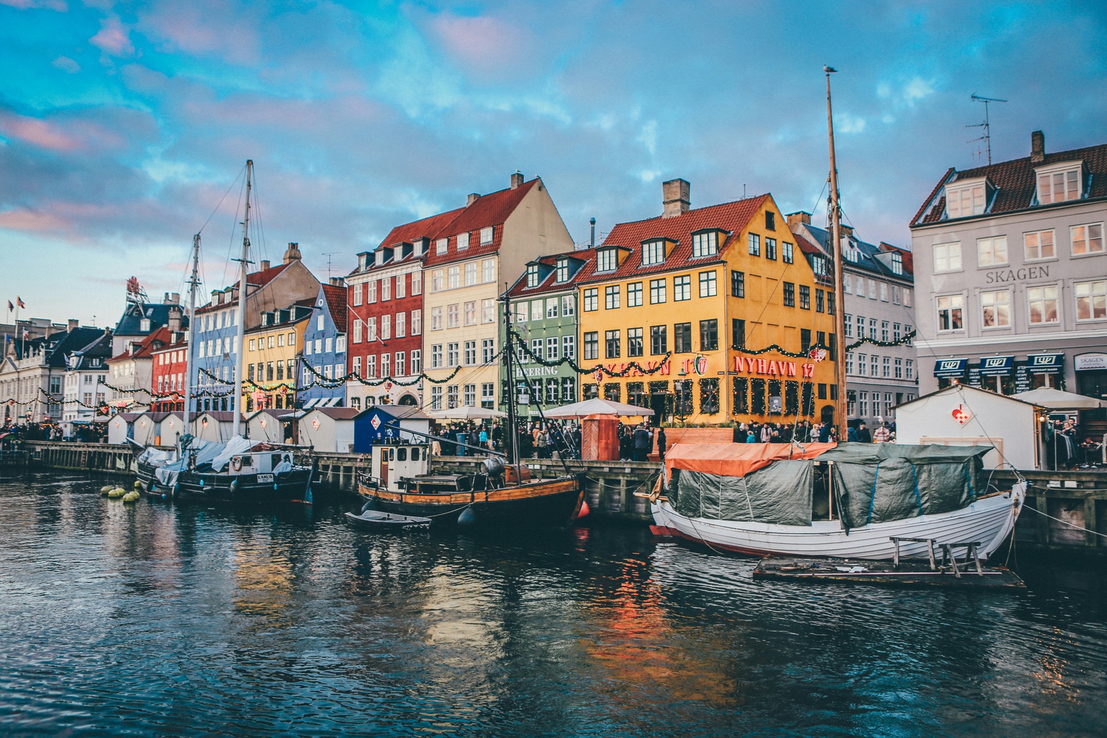 Le case colorate di Nyhavn al tramonto, con le barche di legno ormeggiate lungo il canale