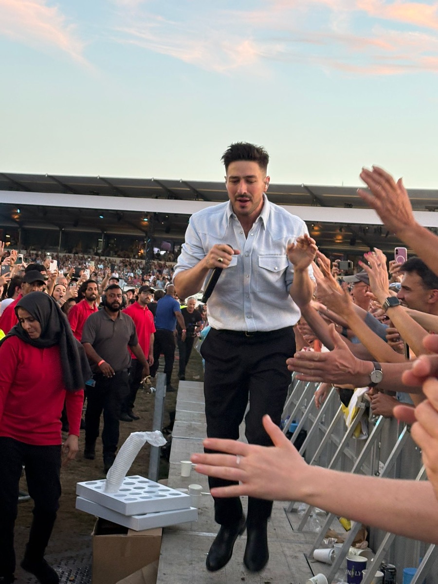 Close-up of Marcus Mumford walking through the Hyde Park pit crowd, passing a few metres from the front barrier during Ditmas
